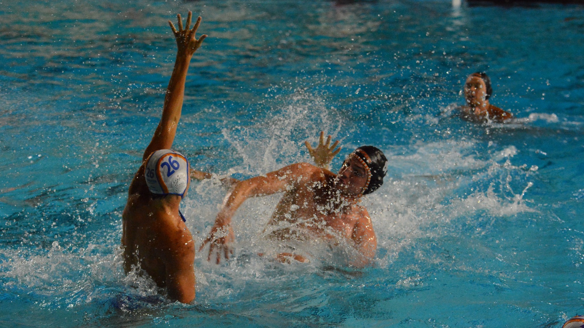 Bram Schork follows through on his shot against Pomona-Pitzer, white droplets of water radiate from the center of the frame from the splash of his shooting hand hitting the water