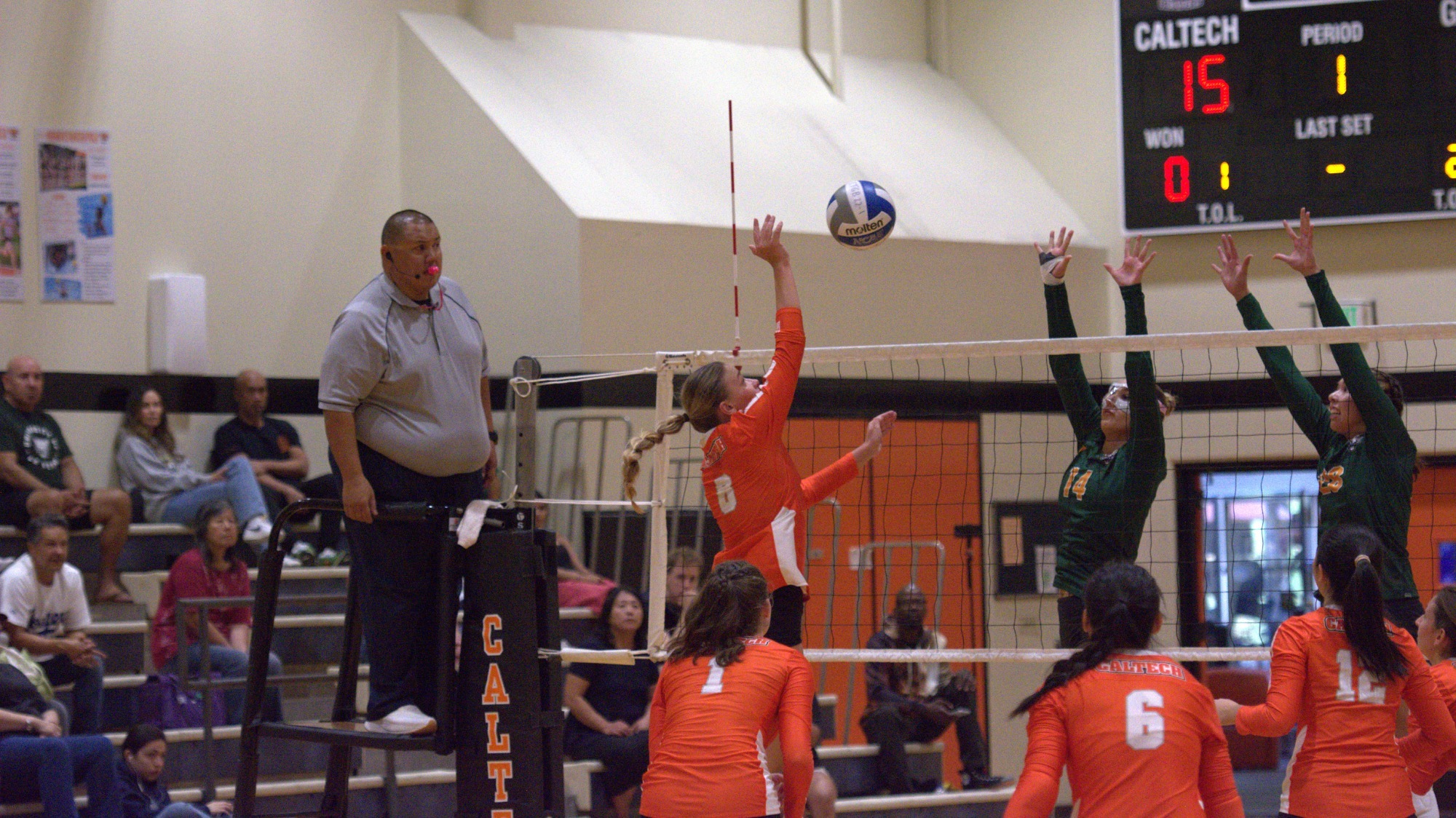 Alize Bakker makes a right-handed attack from the left side of the net viewed diagonally from behind, the 