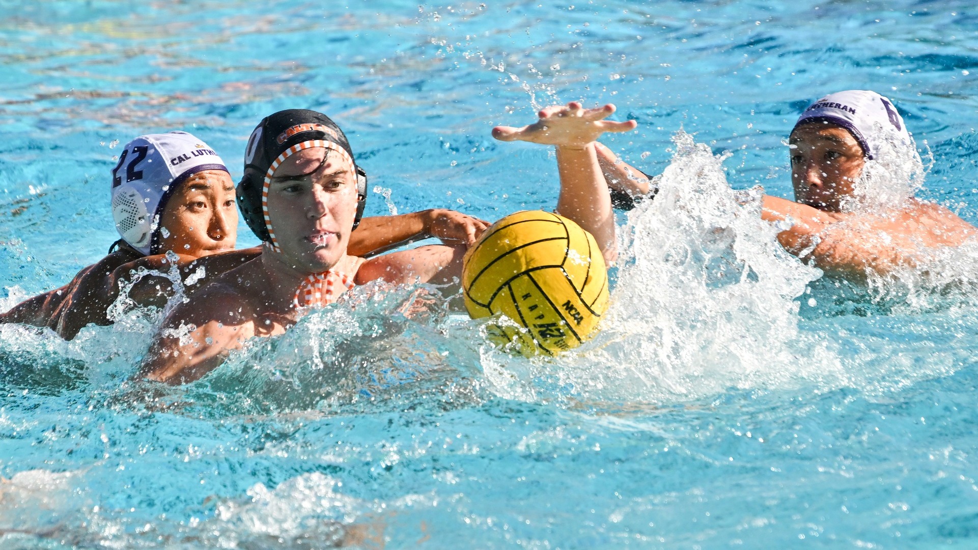 Joshua Braun looks to gain possession of a loose ball, flanked by two Cal Lutheran players