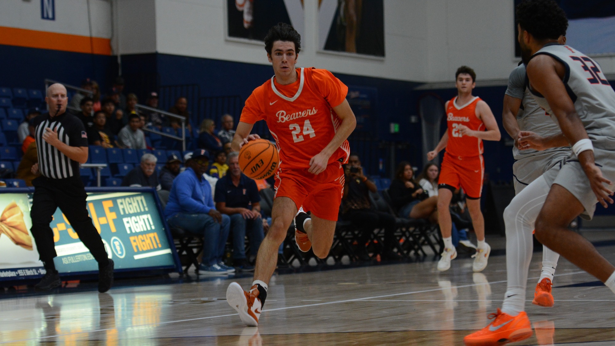 Dorian Glogovac Dribbles at a full sprint in transition on the right side of the court past a defender while controlling the ball in his right hand and beginning to lower his right shoulder. 