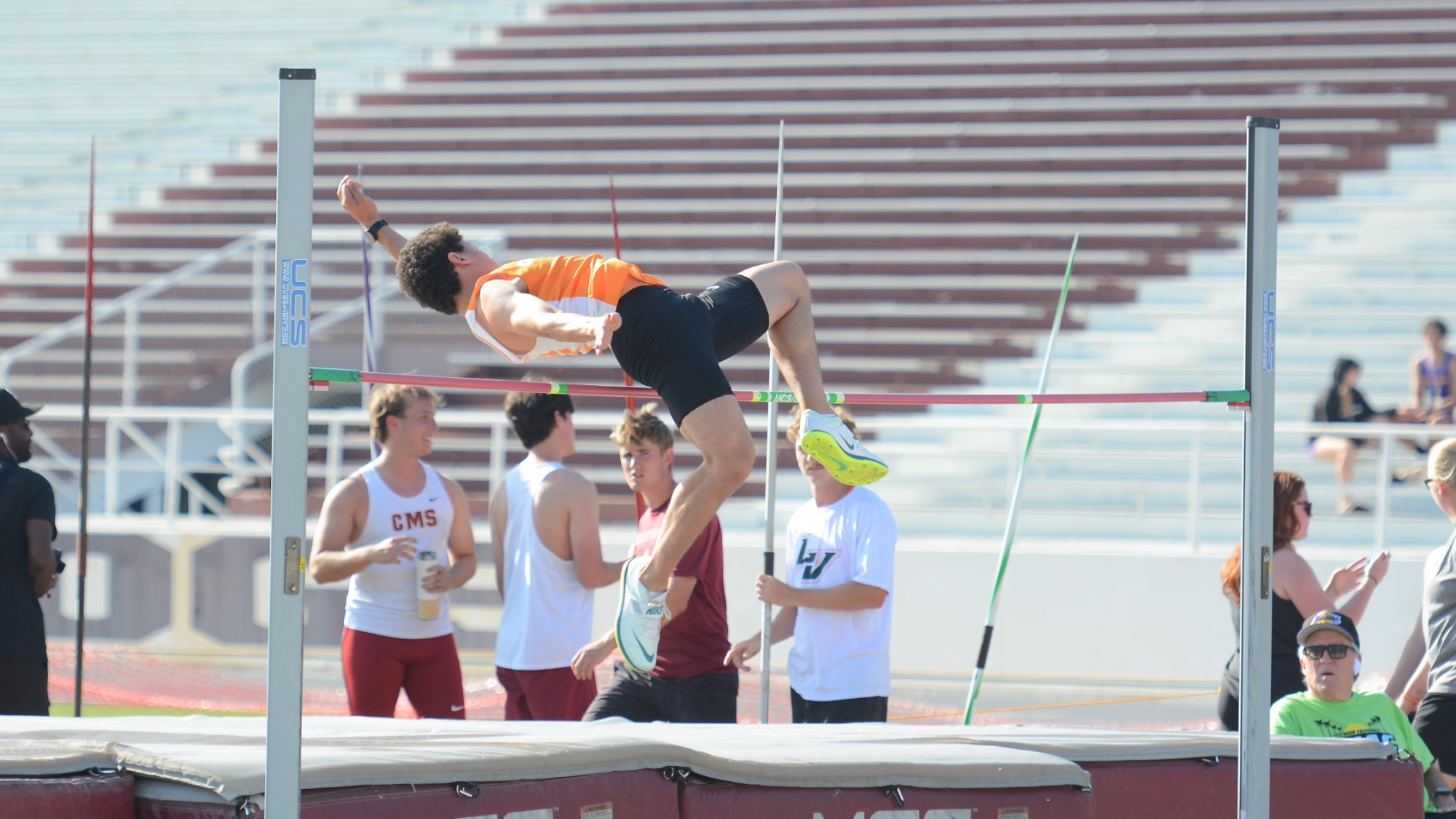 Tyler Gatewood contorts his body over the bar as he executes a high jump at the SCIAC Championships as three other competitors look on. 