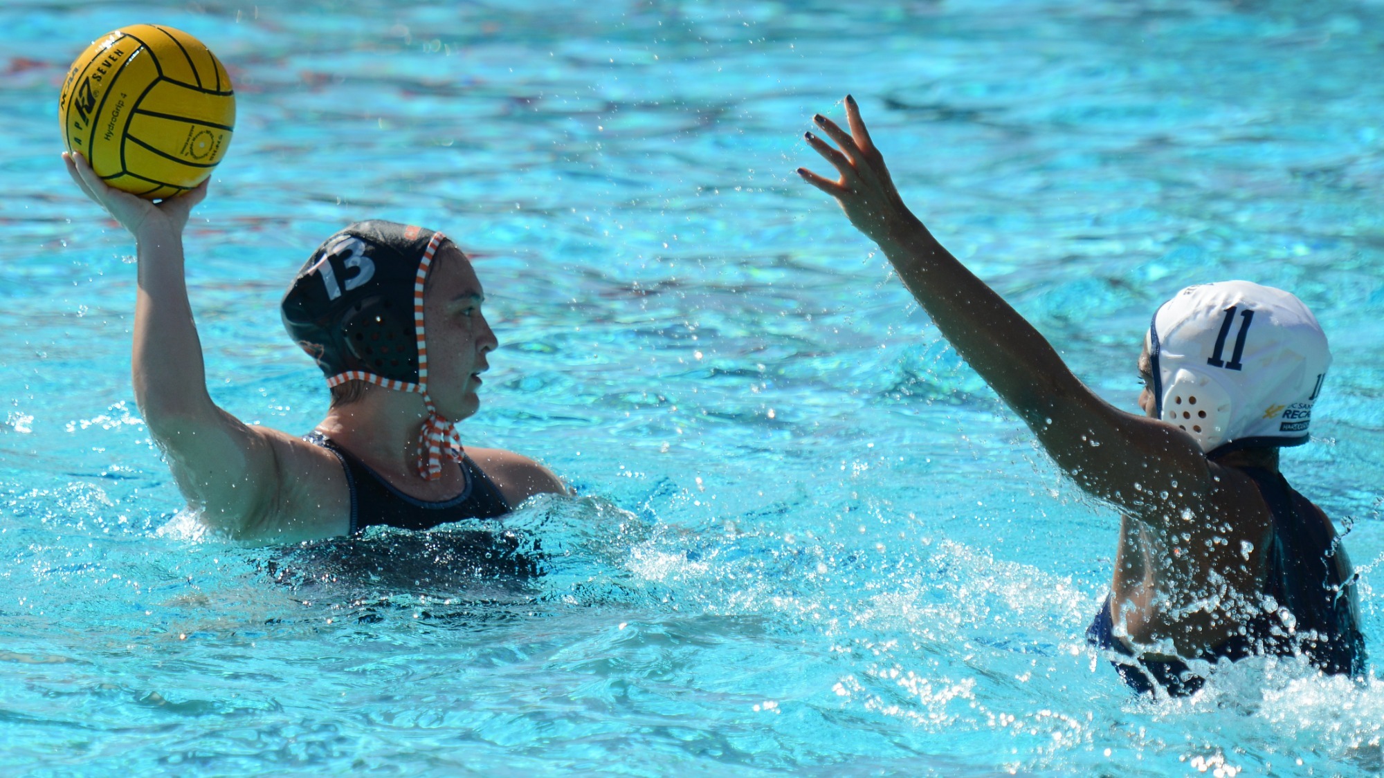 Maya Dickson holds the ball behind her head under defensive pressure as she surveys her options. 