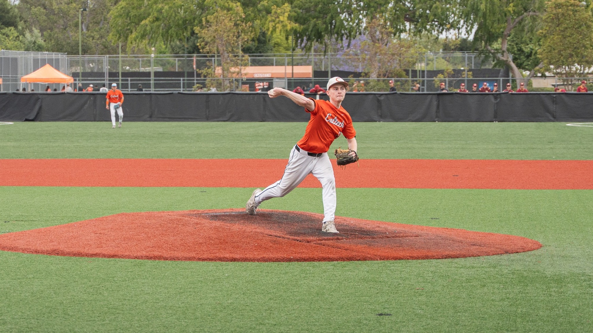Brendan Flaherty reaches behind his head with the ball in his hand as he strides forward to deliver a pitch
