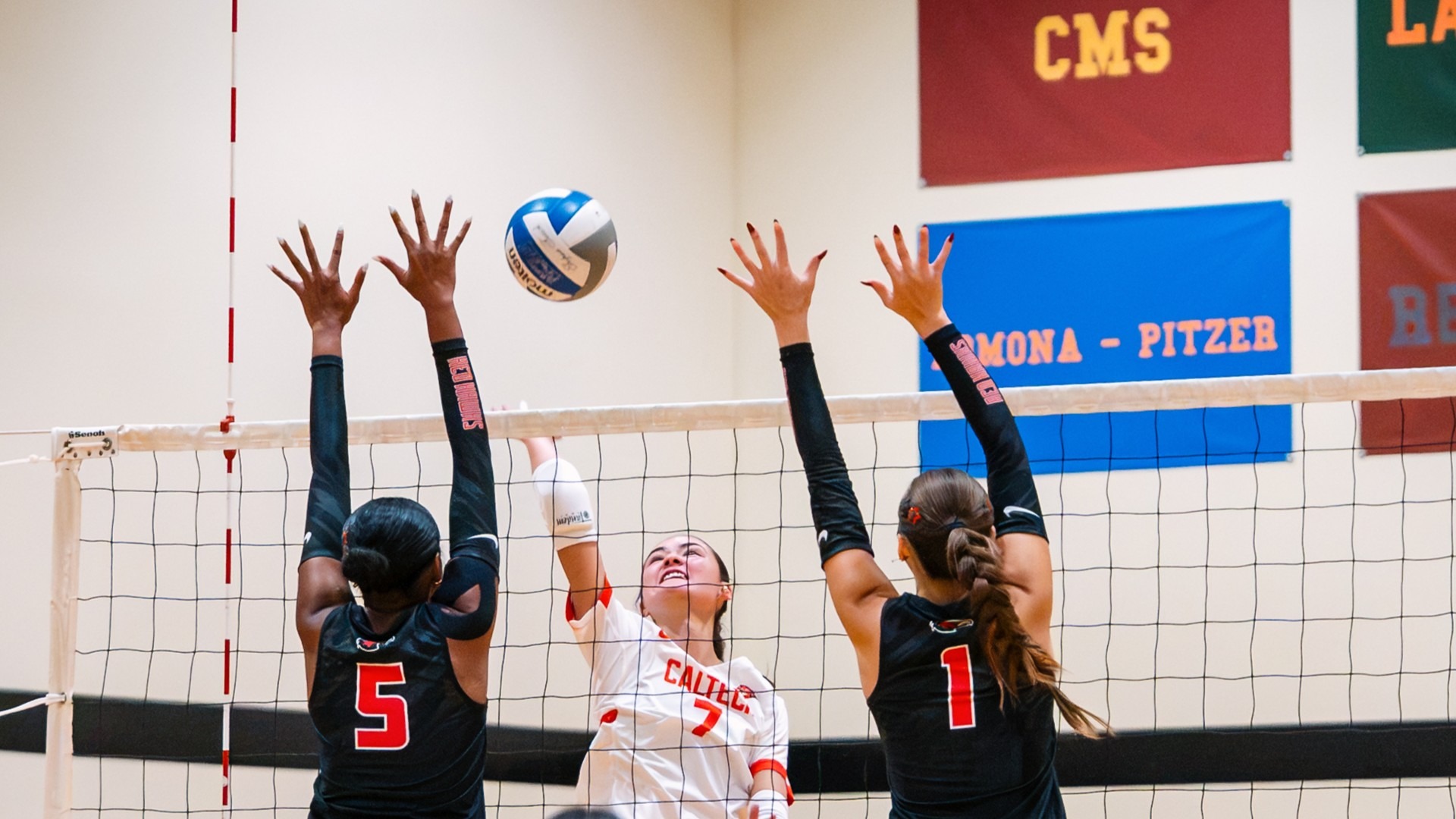 Emma Berg aims an attack between the hands of two blockers against Simpson 