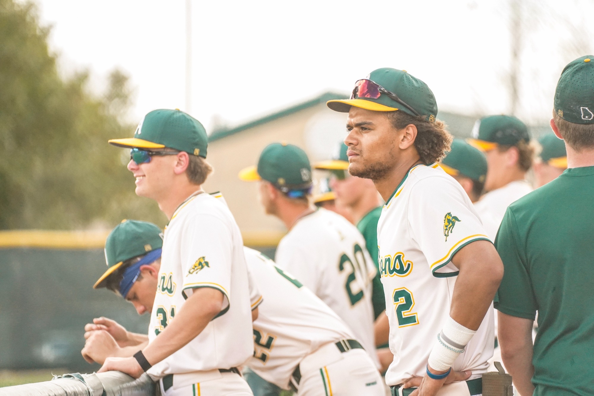 ABAC baseball players cheer on teammates from the dugout