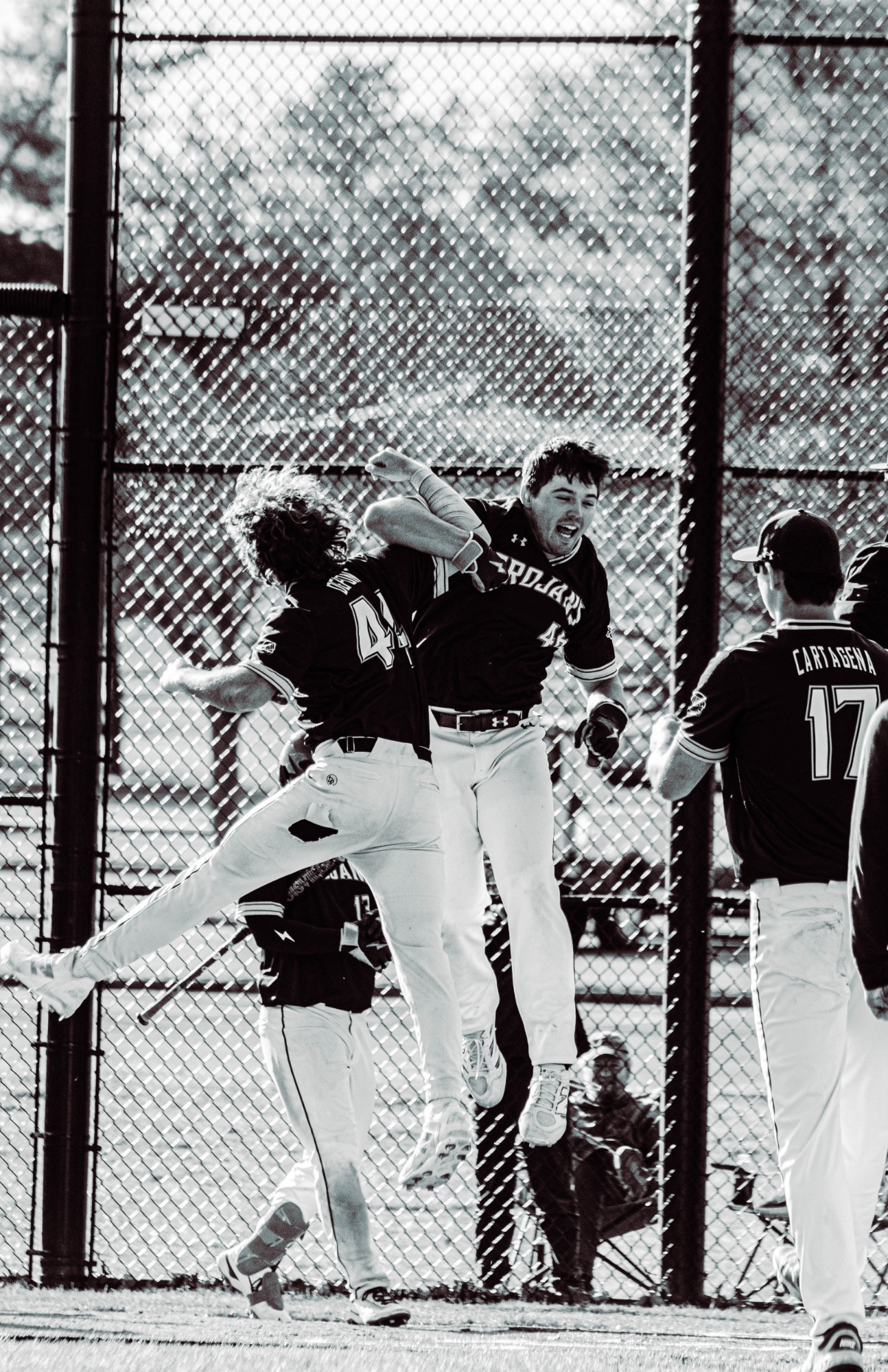 Two teammates cheering on and jumping in celebration 