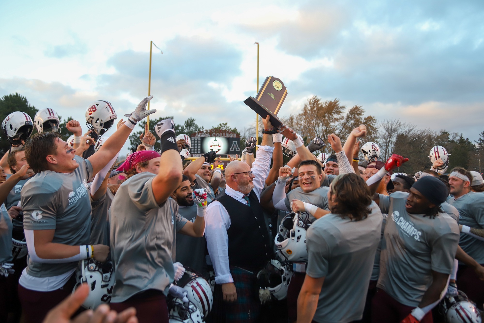 Football celebrates with the 2025 MIAA championship trophy