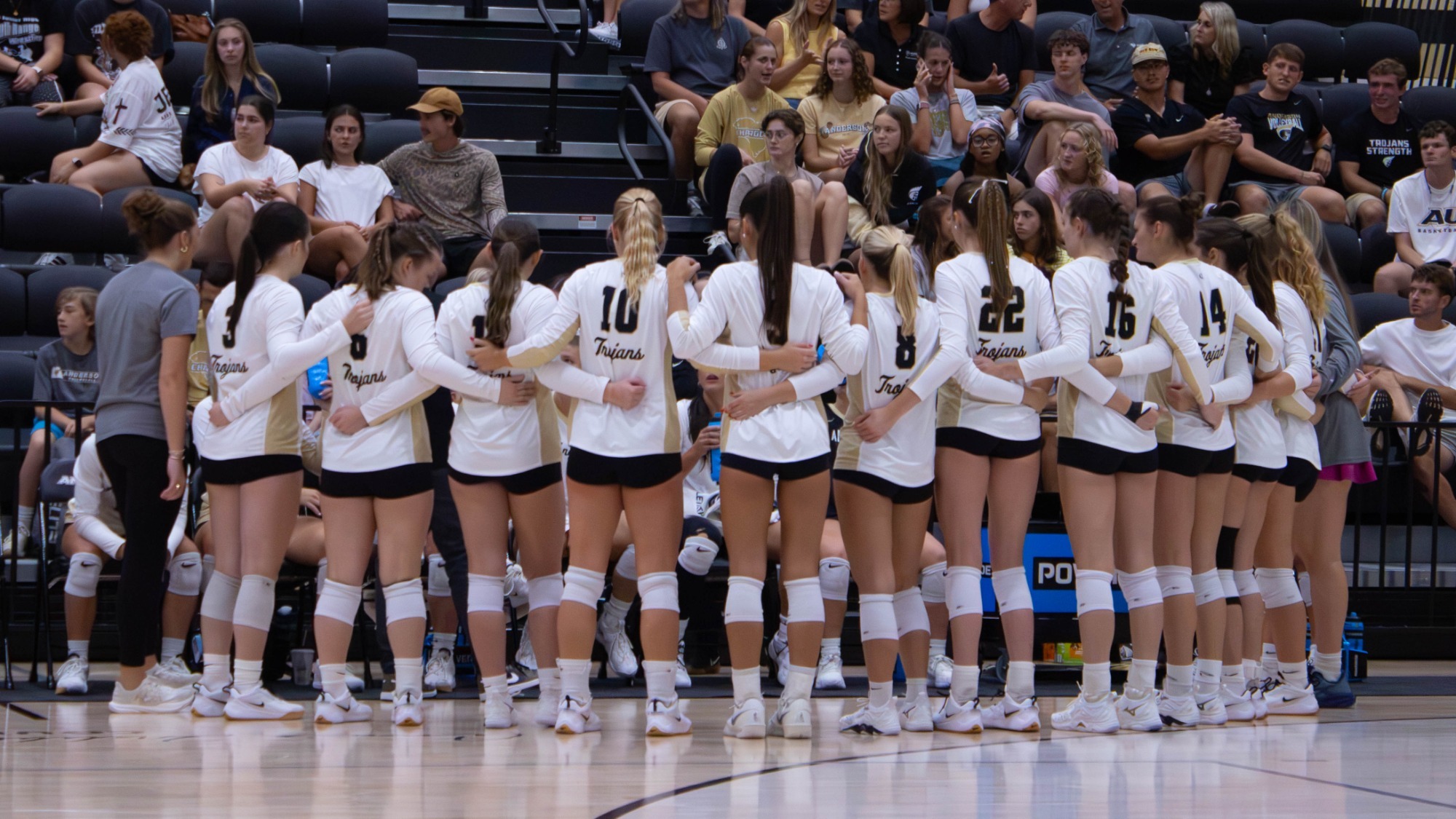 Women's volleyball huddles during a timeout 