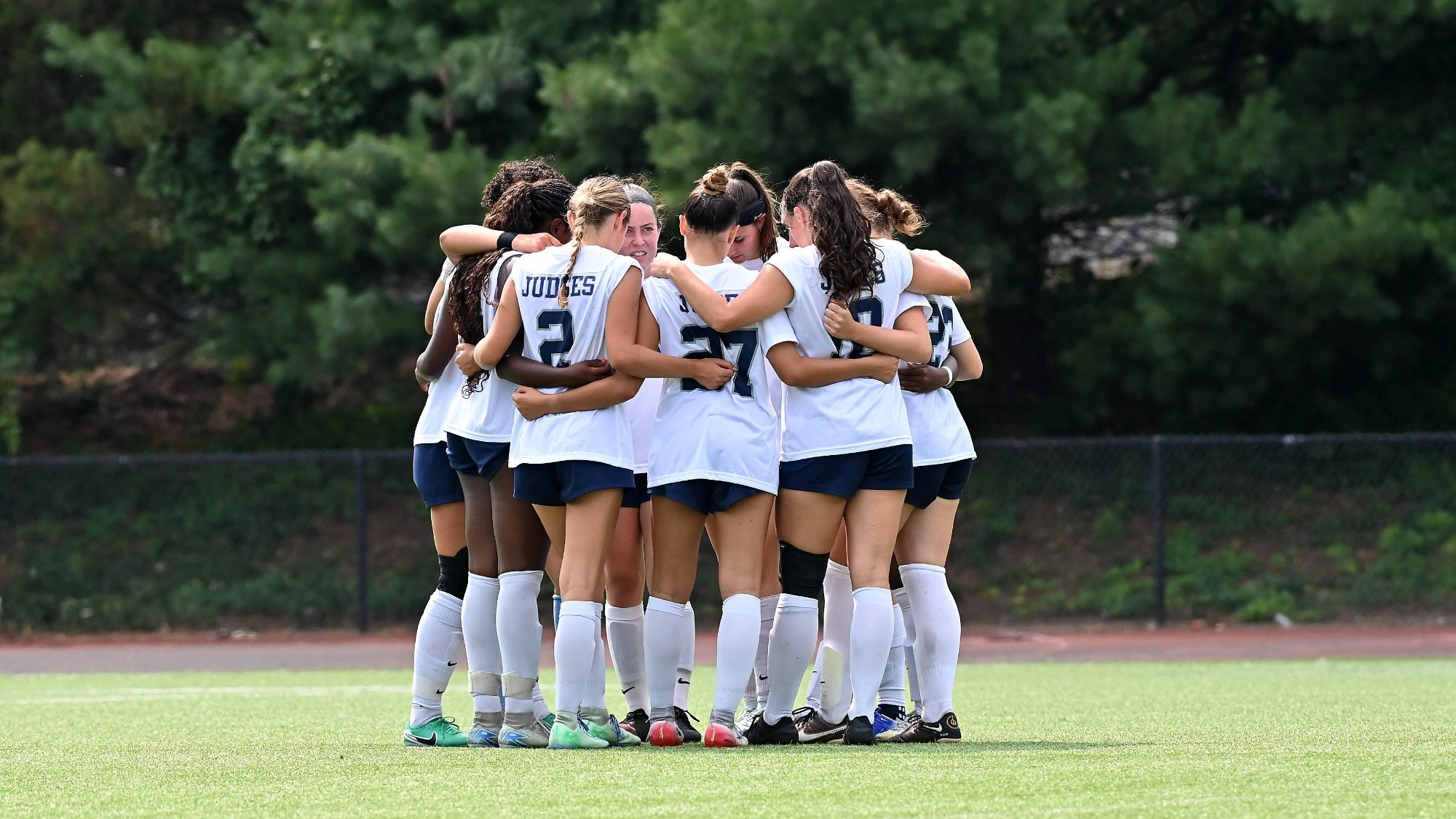 Brandeis women's soccer team huddles up before a game