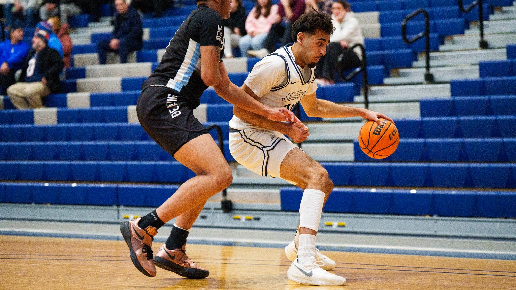 Ghur Dillon looks to dribble past a defender in the Brandeis men's basketball game against UMass Boston