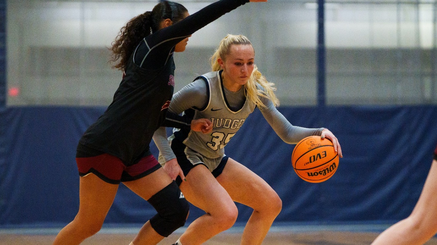 Abby Kennedy dribbles past a defender during a basketball game
