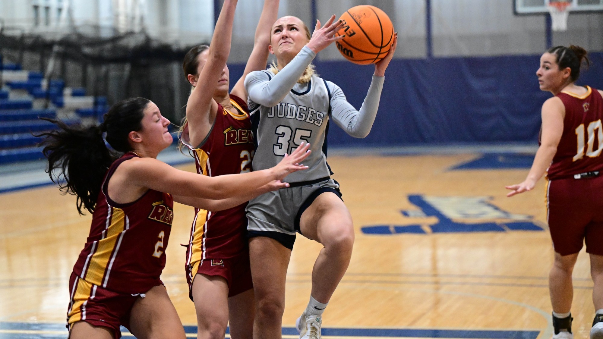 Abby Kennedy puts up a contested shot in the lane against two defenders in a basketball game