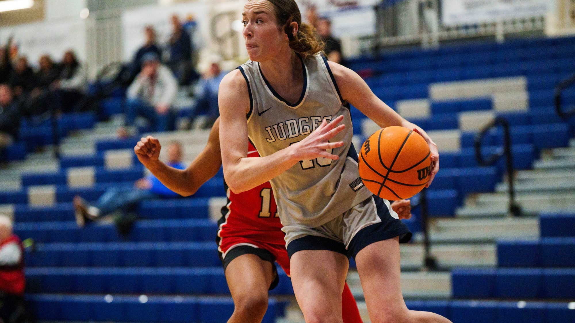 Katherine Vaughan dribbles past a defender during a basketball game