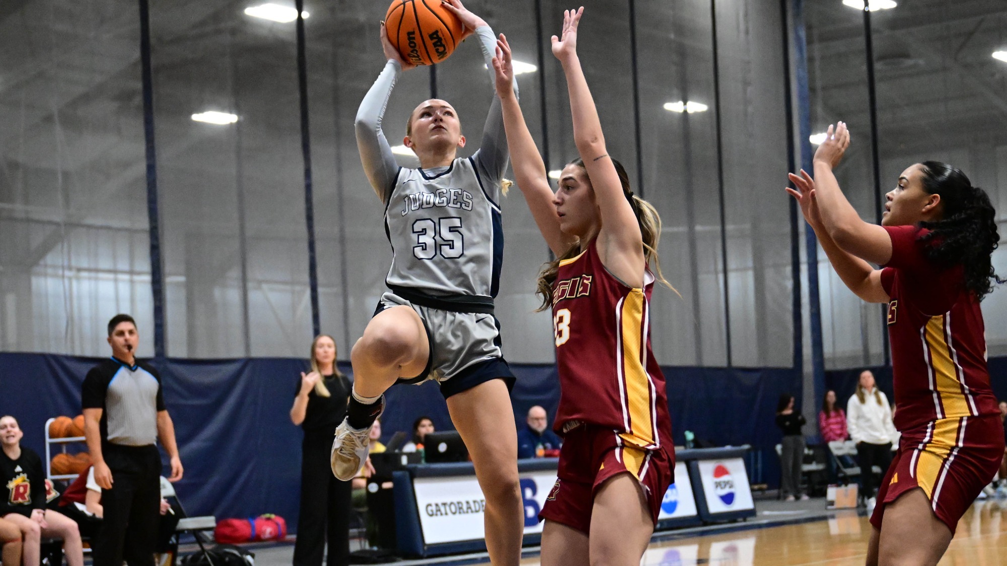 Abby Kennedy grabs a rebound during a basketball game against Regis