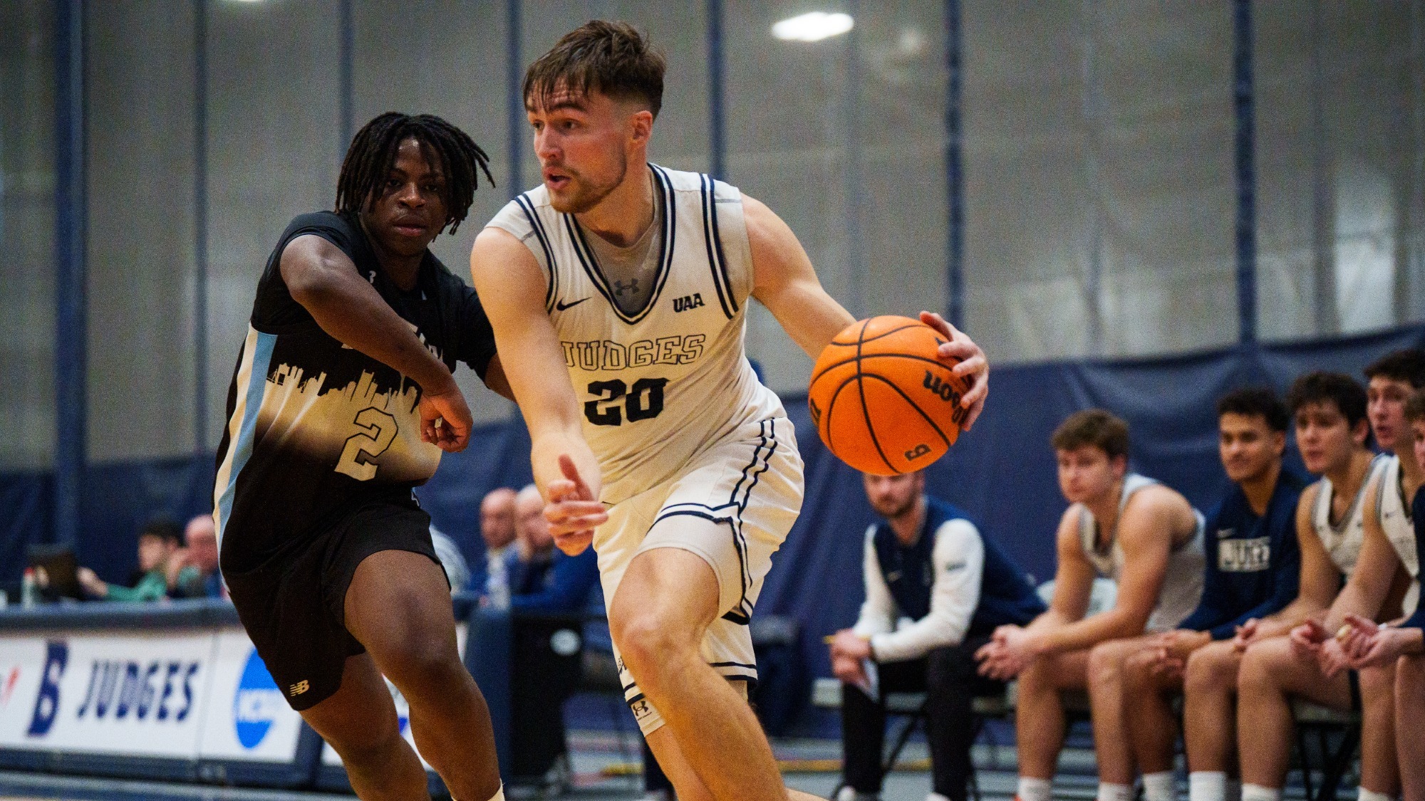 Elias Rodl dribbles by an opponent during a men's basketball game