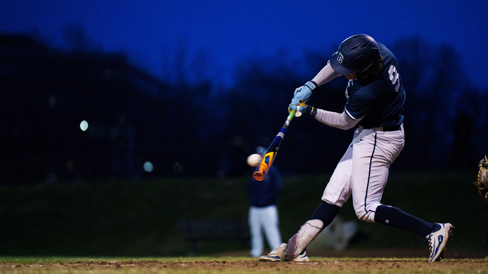 Dylan Walsh hitting a baseball during a game at night