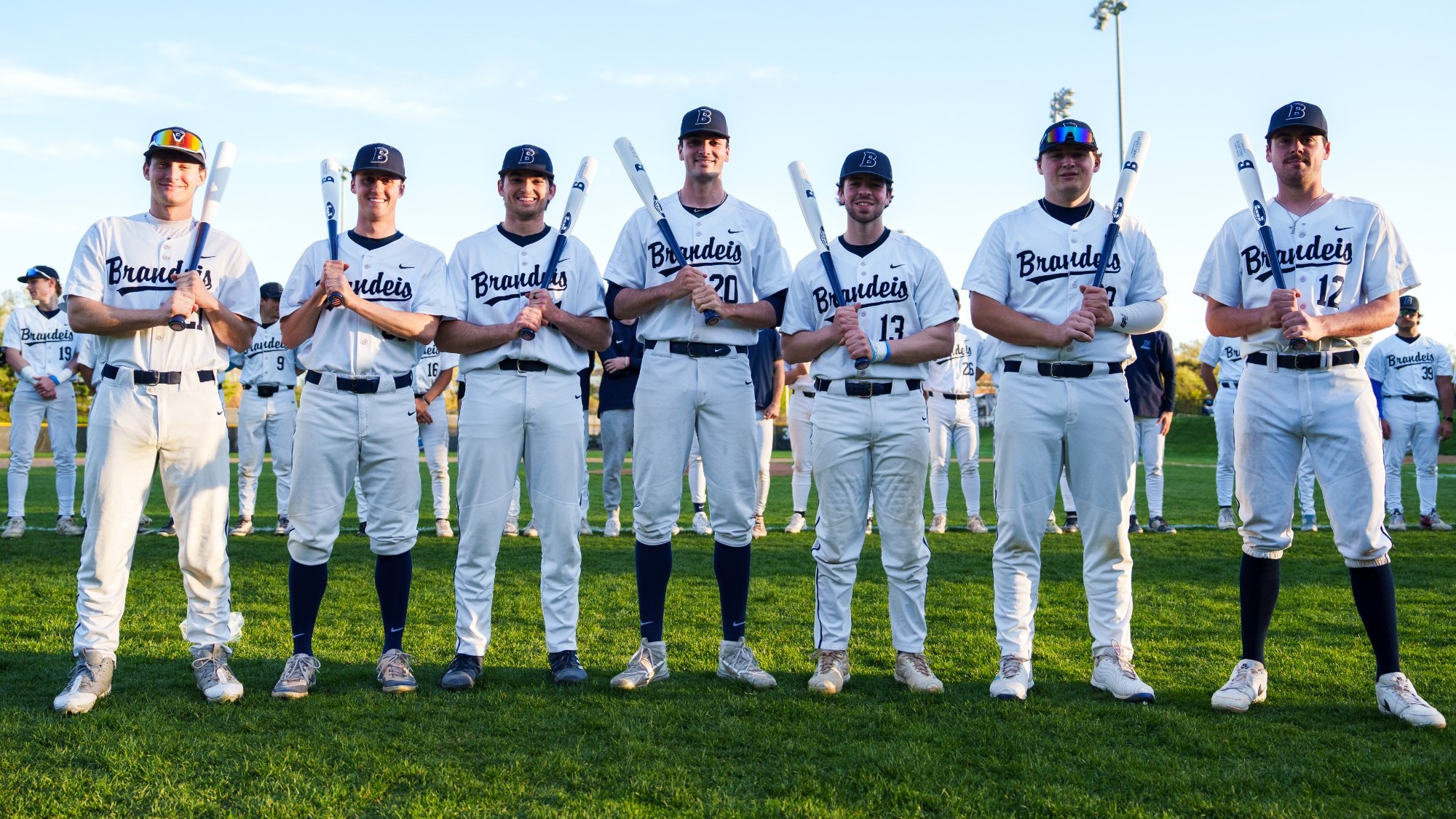 Brandeis senior baseball players with Senior Day gift bats on their shoulders