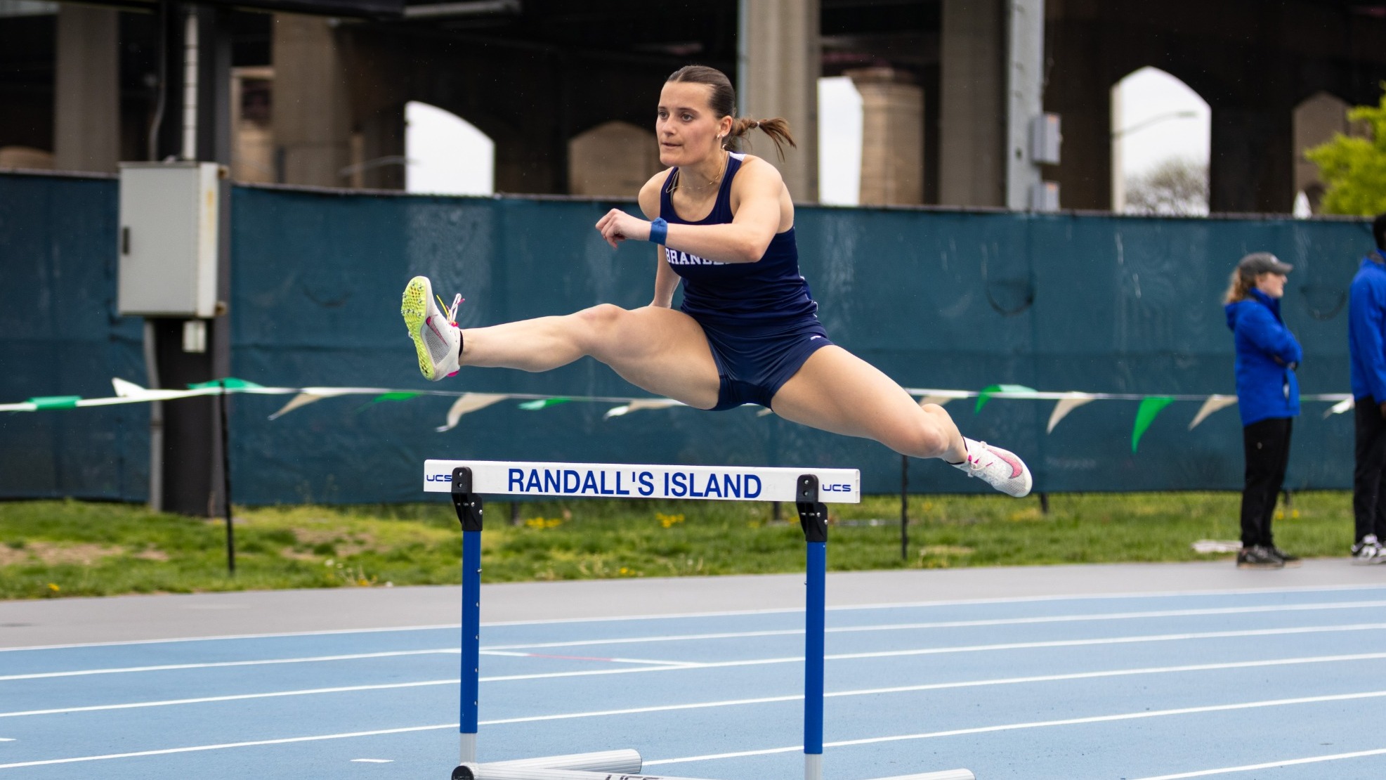 Natalie Liapis jumps over a hurdle during the UAA Championships