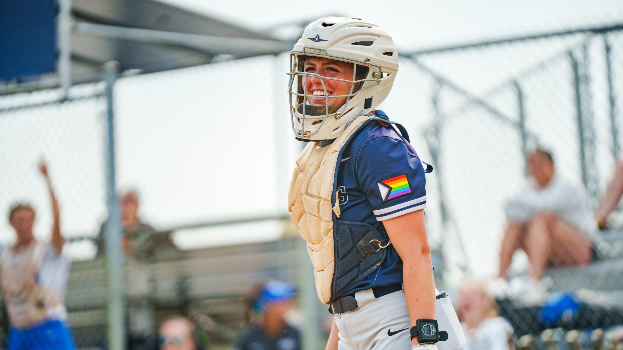 Tristan Boyer in her catcher's gear during a softball game, smiling