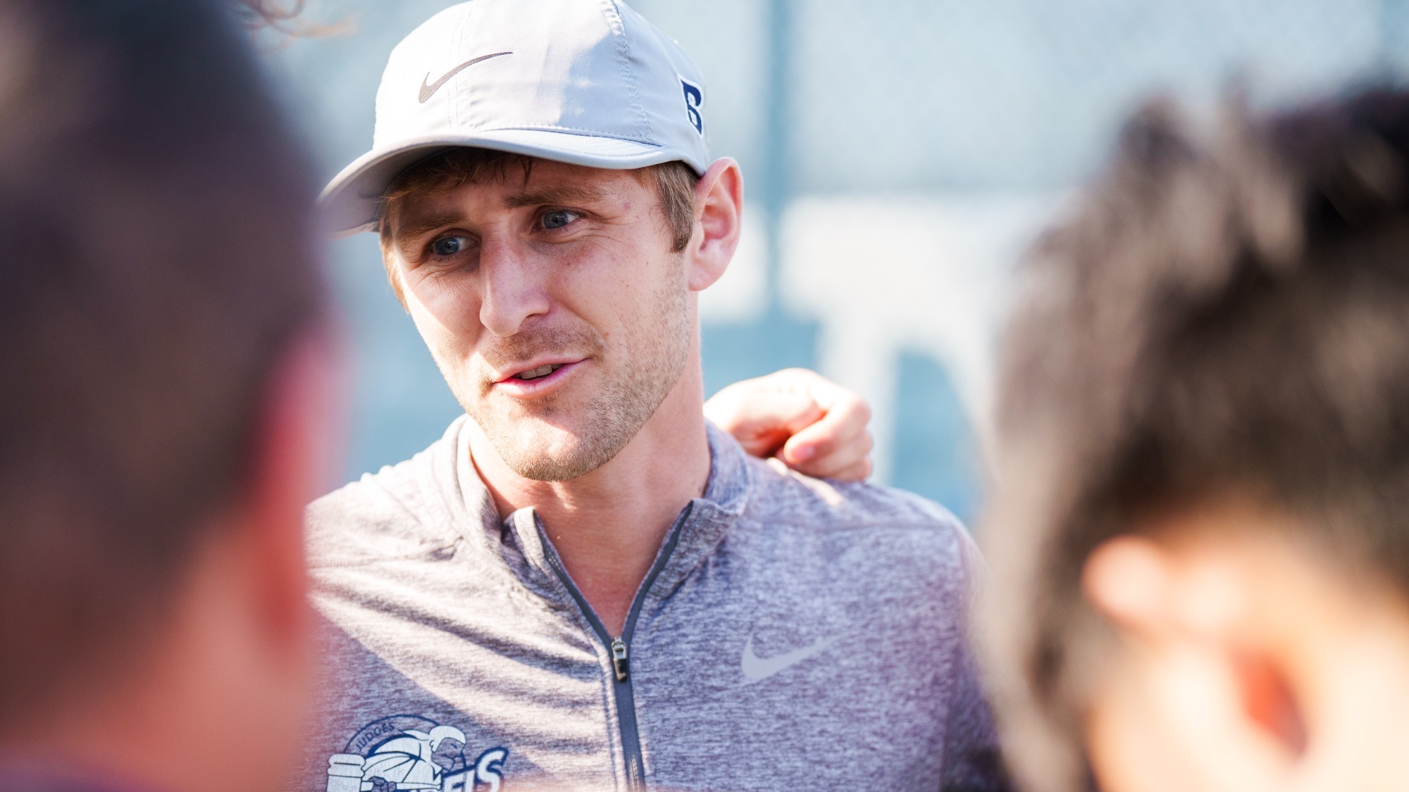 Men's tennis coach Christo Schultz talks to his team in a huddle