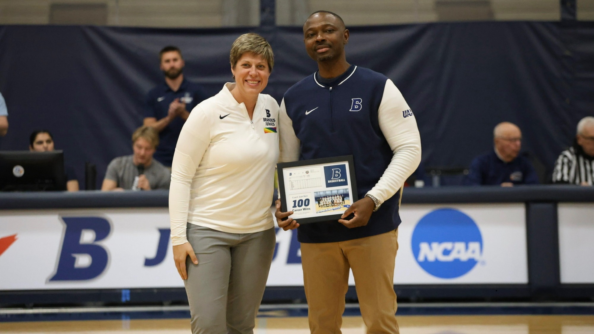 Athletic Director Jess Chapin presents Jean Bain with a plaque honoring his 100th career win