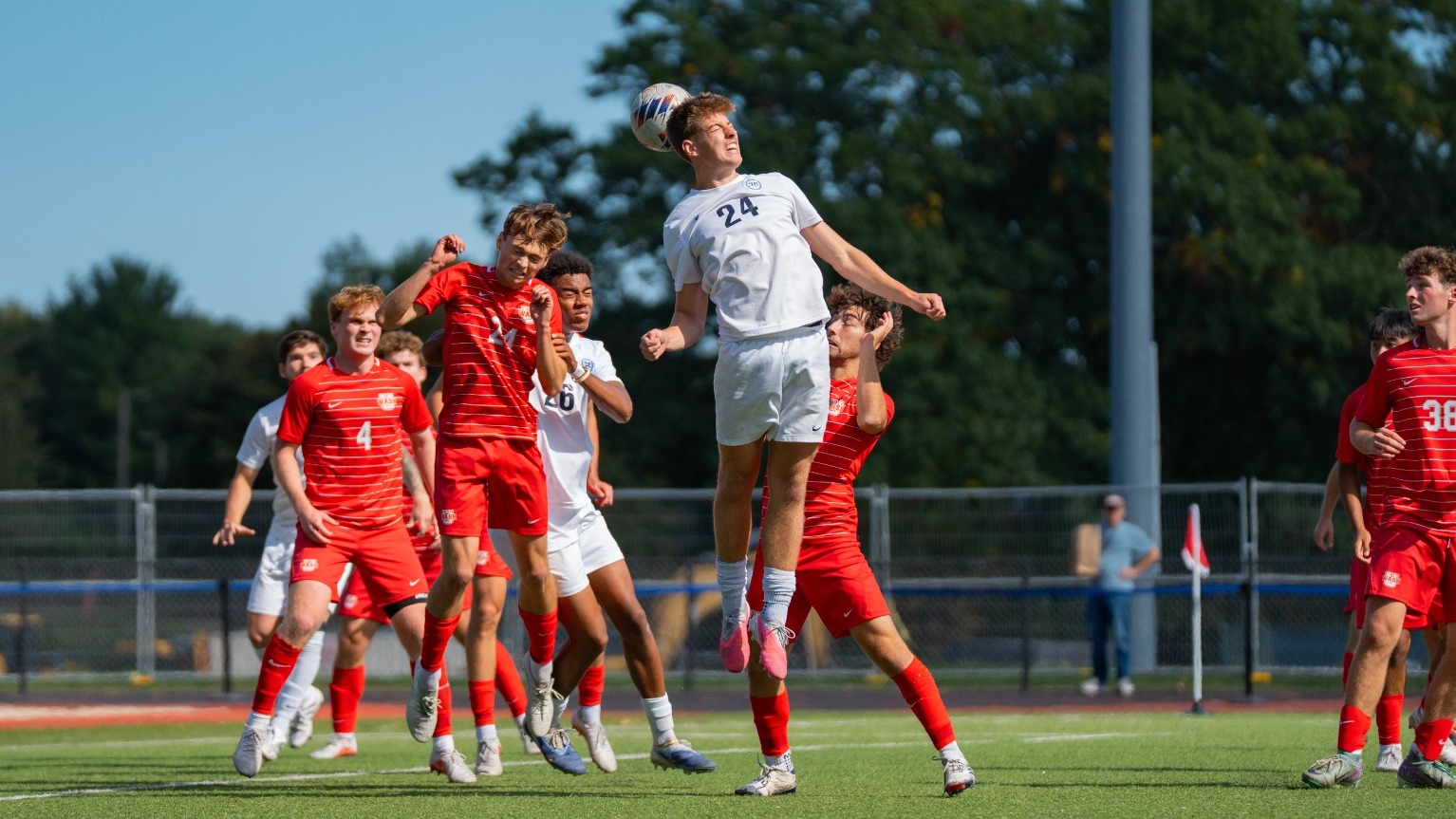 Jack Rossiter goes up high for a header in front of several defenders during a soccer match