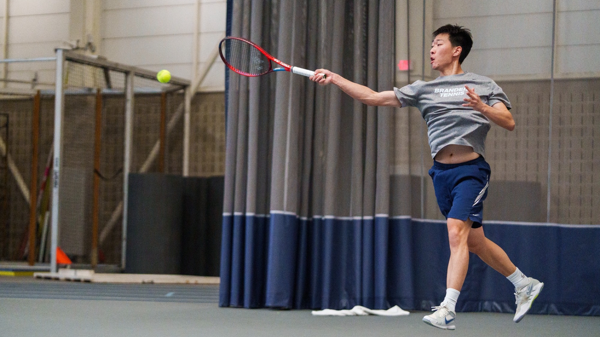 Huasen Dong hits a forehand during a tennis match