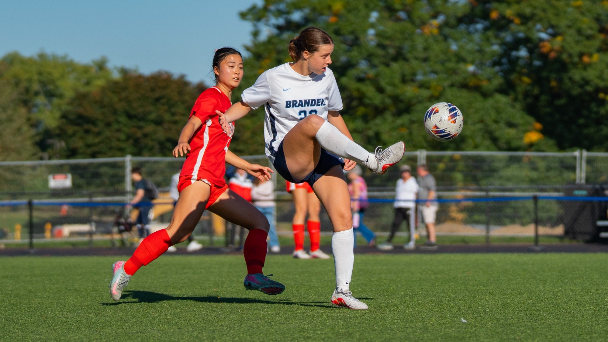 Grace Carman plays the ball ahead with a high kick during a soccer match