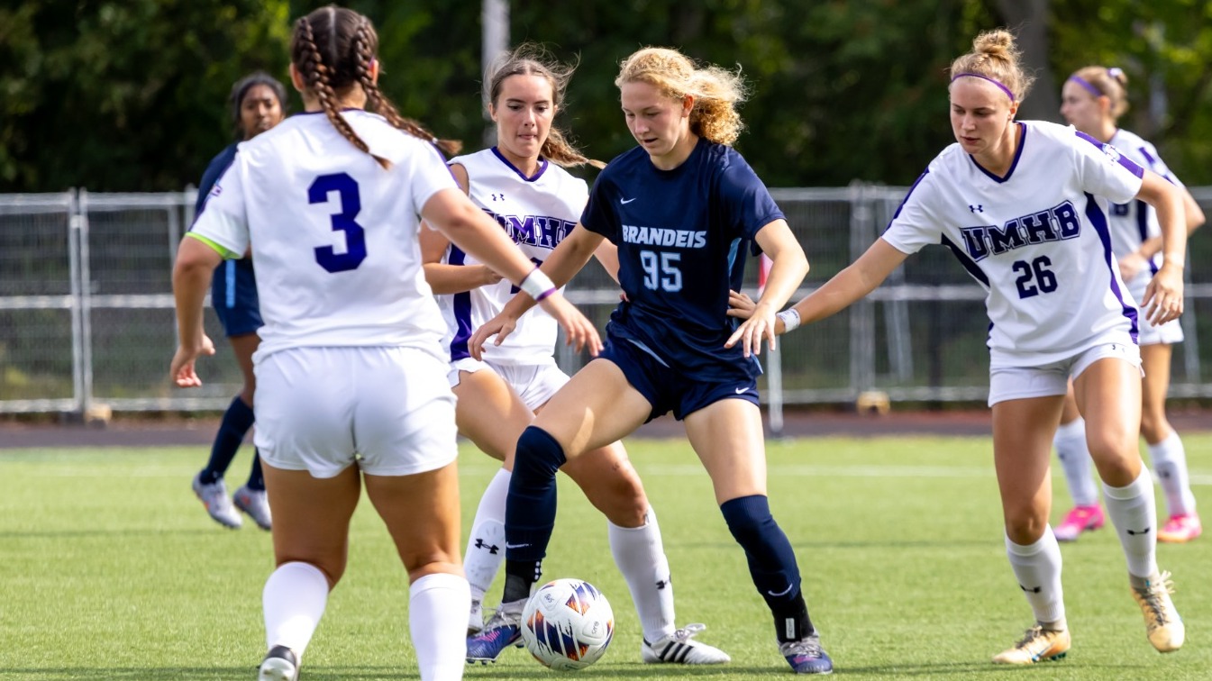 Valerie Bunde plays the ball at her feet with defenders surrounding her during a soccer match