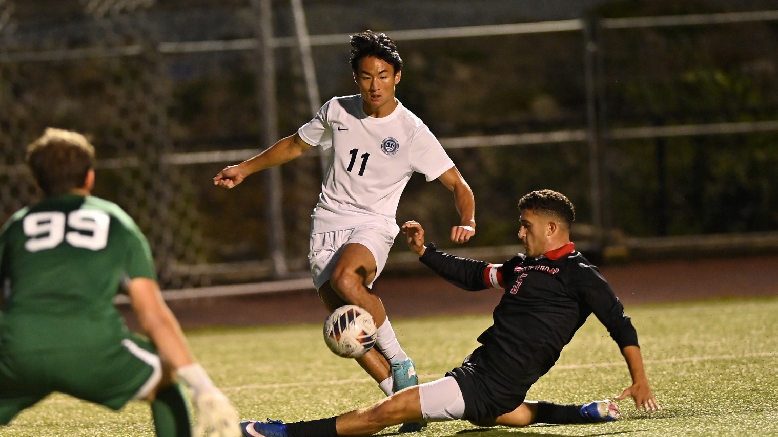 Aidan Chuang tries to avoid a slide tackle during a soccer match