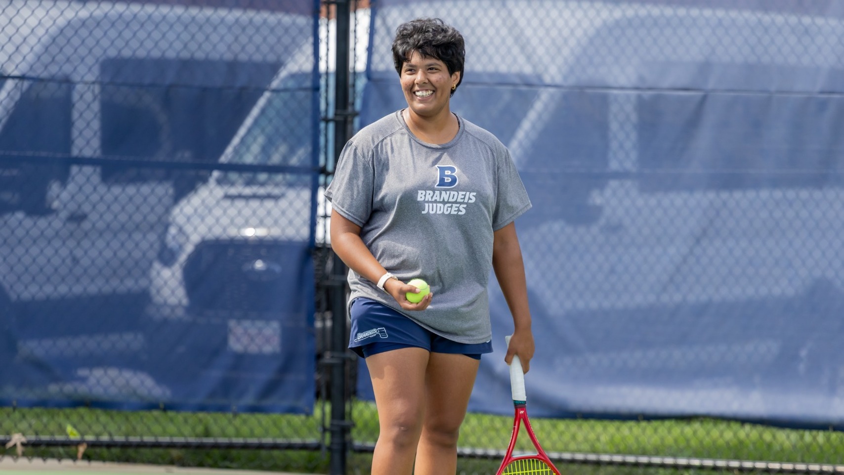 Avani Chitale smiles as she gets ready to serve during a tennis match