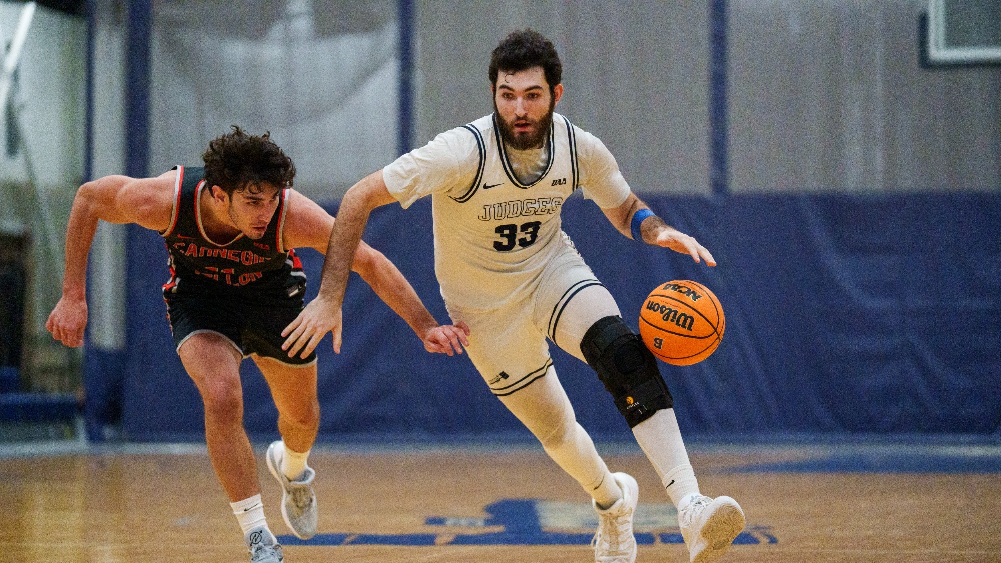 Aedan Using dribbles past a defender during a basketball game