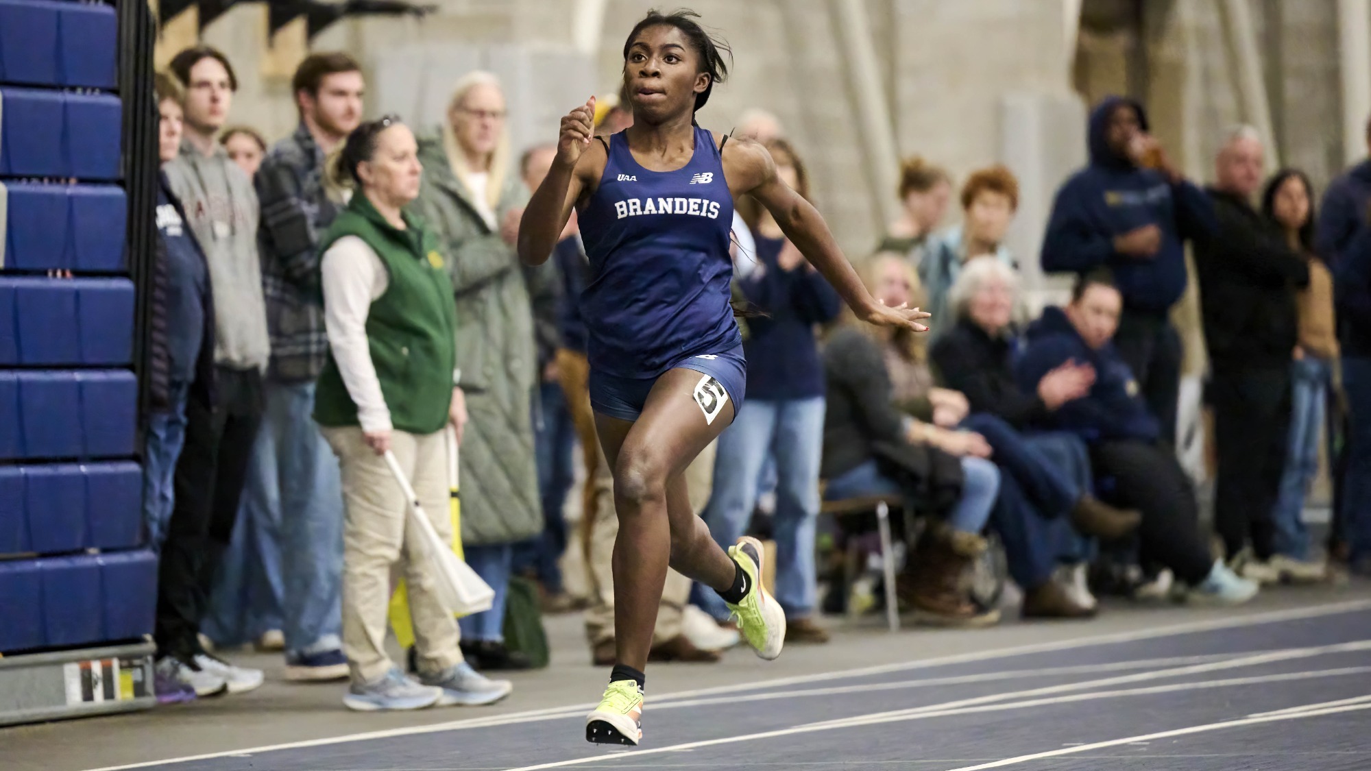 Peterly Leroy running a race with a crowd watching behind her