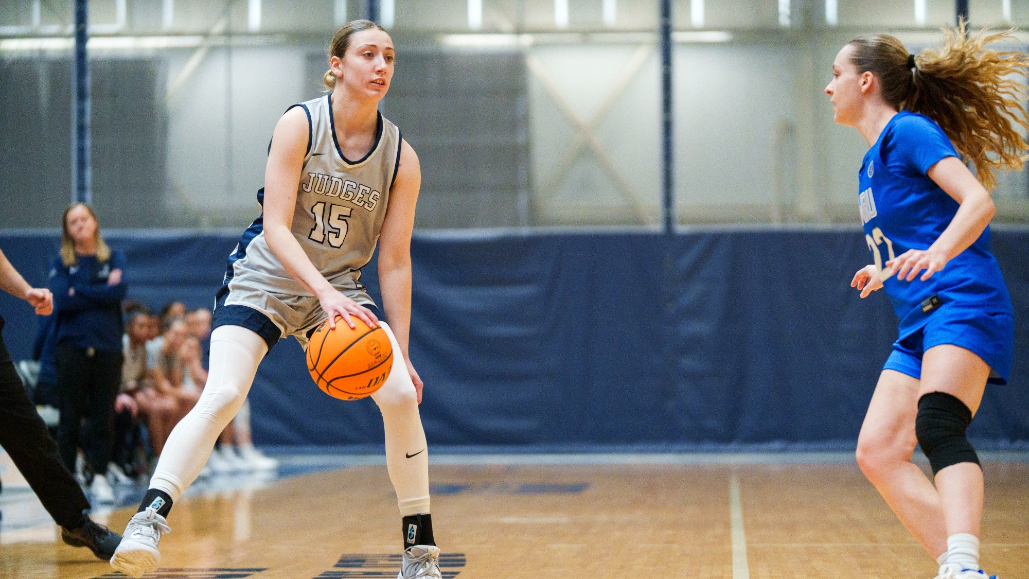 Sophia Berisha handles the ball with a defender on her in a basketball game