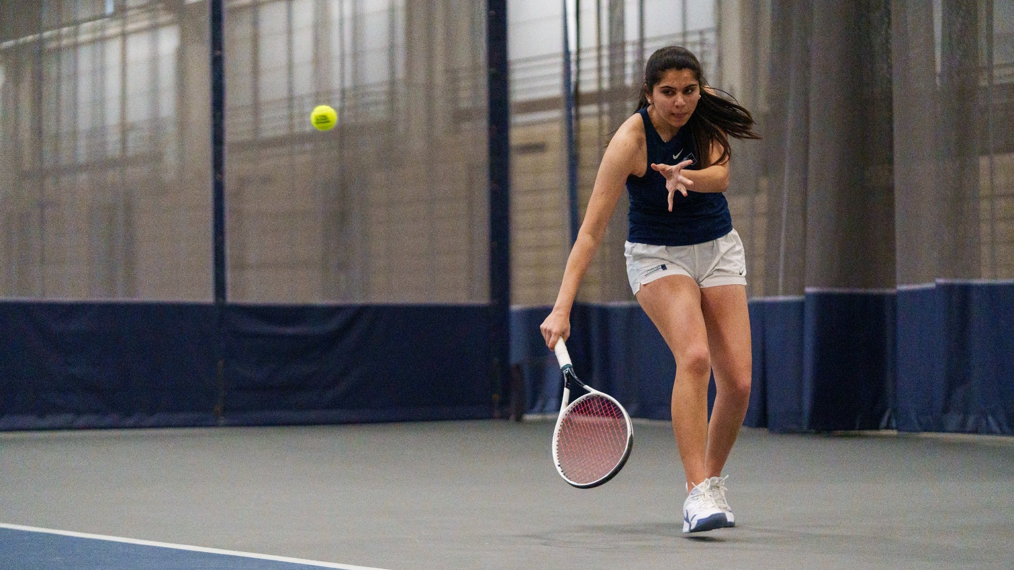 Chahana Budhbhatti hits a return during a tennis match