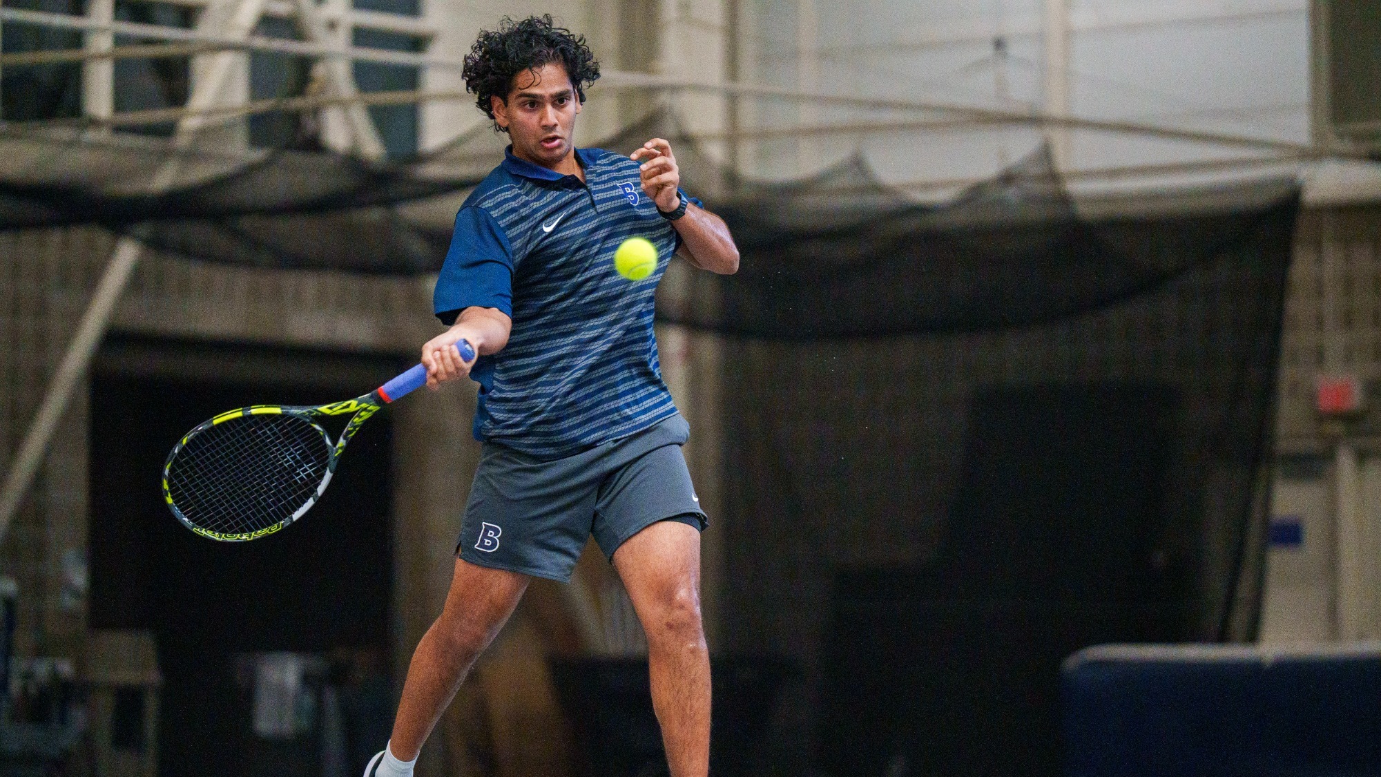 Muaz Malik hits a forehand during a tennis match