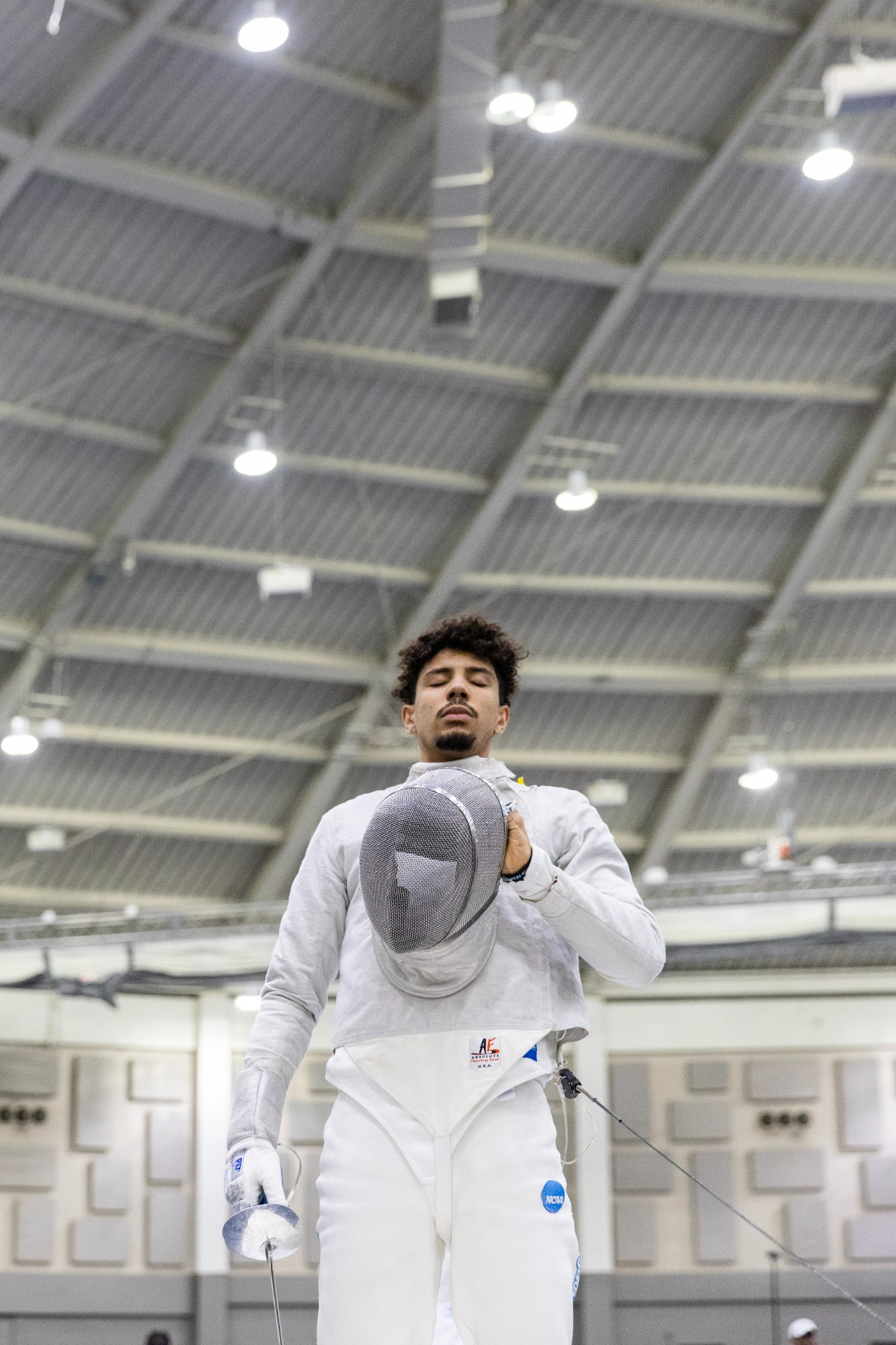 Lev BenAvram with mask in hand takes a deep breath as he prepares to start fencing