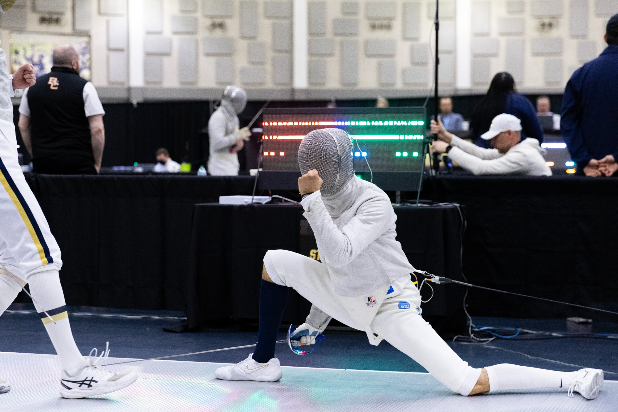Lev BenAvram pumps his fist while deep in a lunch after winning a  touch at the NCAA Fencing Championships