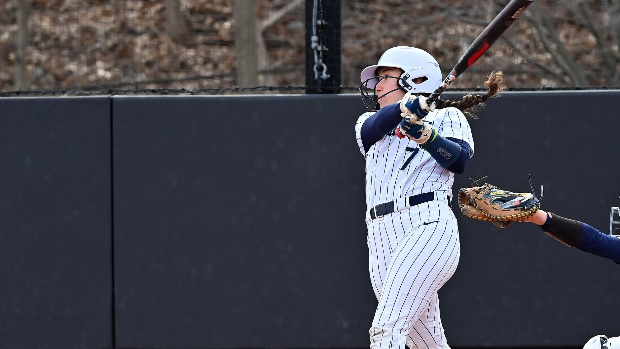 Katie Baydian follows through on her swing during a softball game