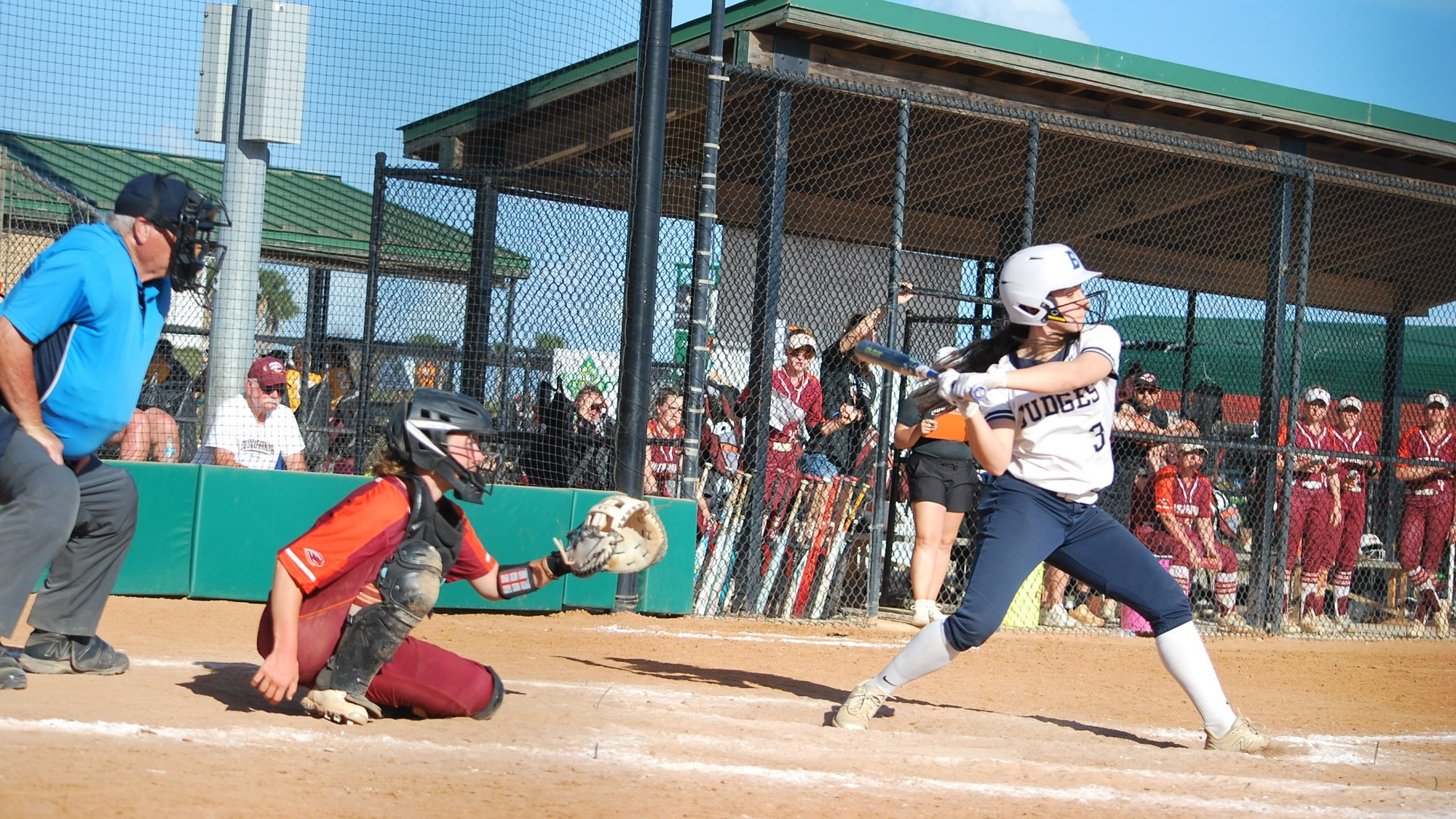 Elle Ehrlich swinging at a pitch during a softball game