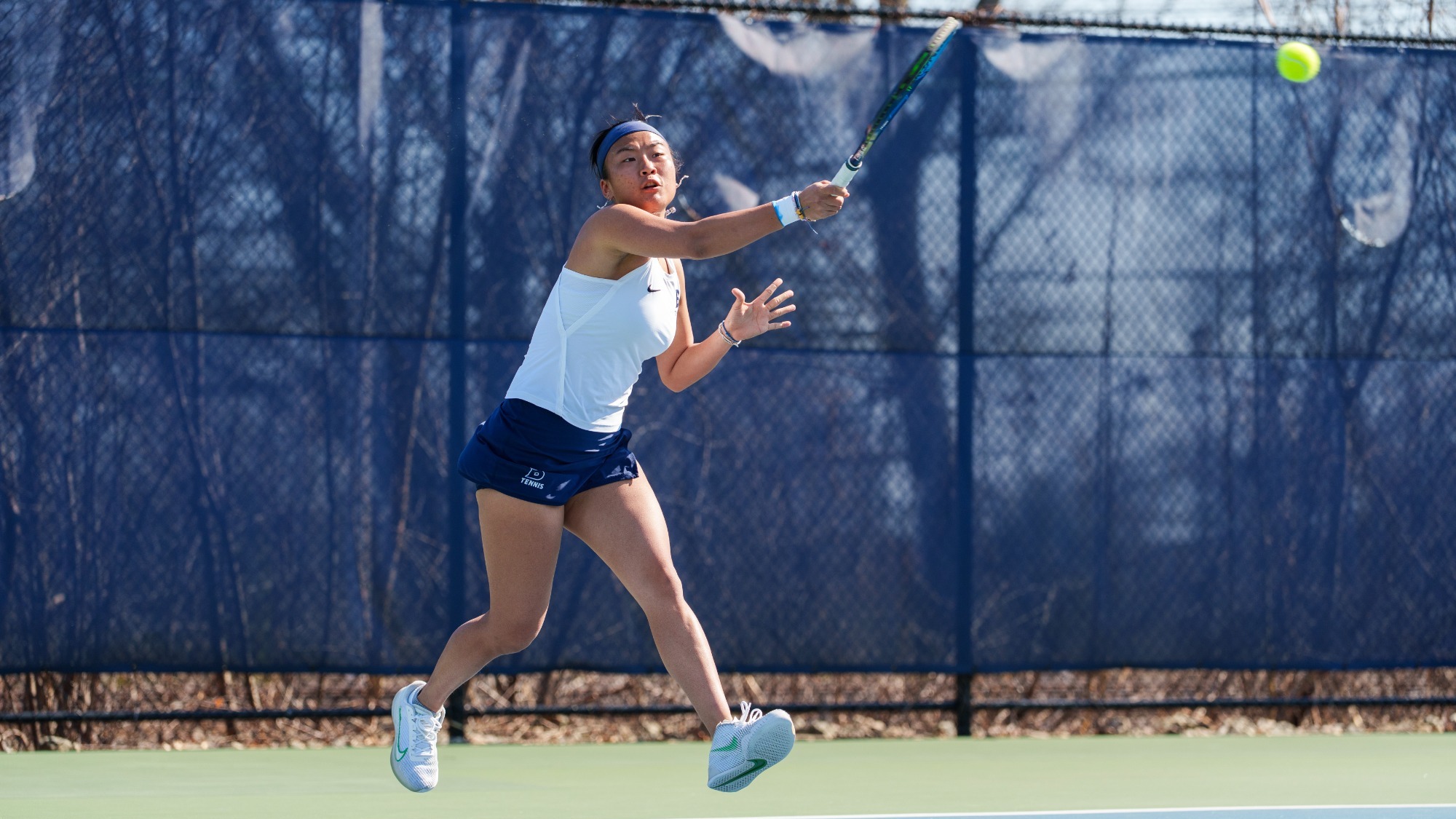Nancy Zhang hits a forehand return during a tennis match