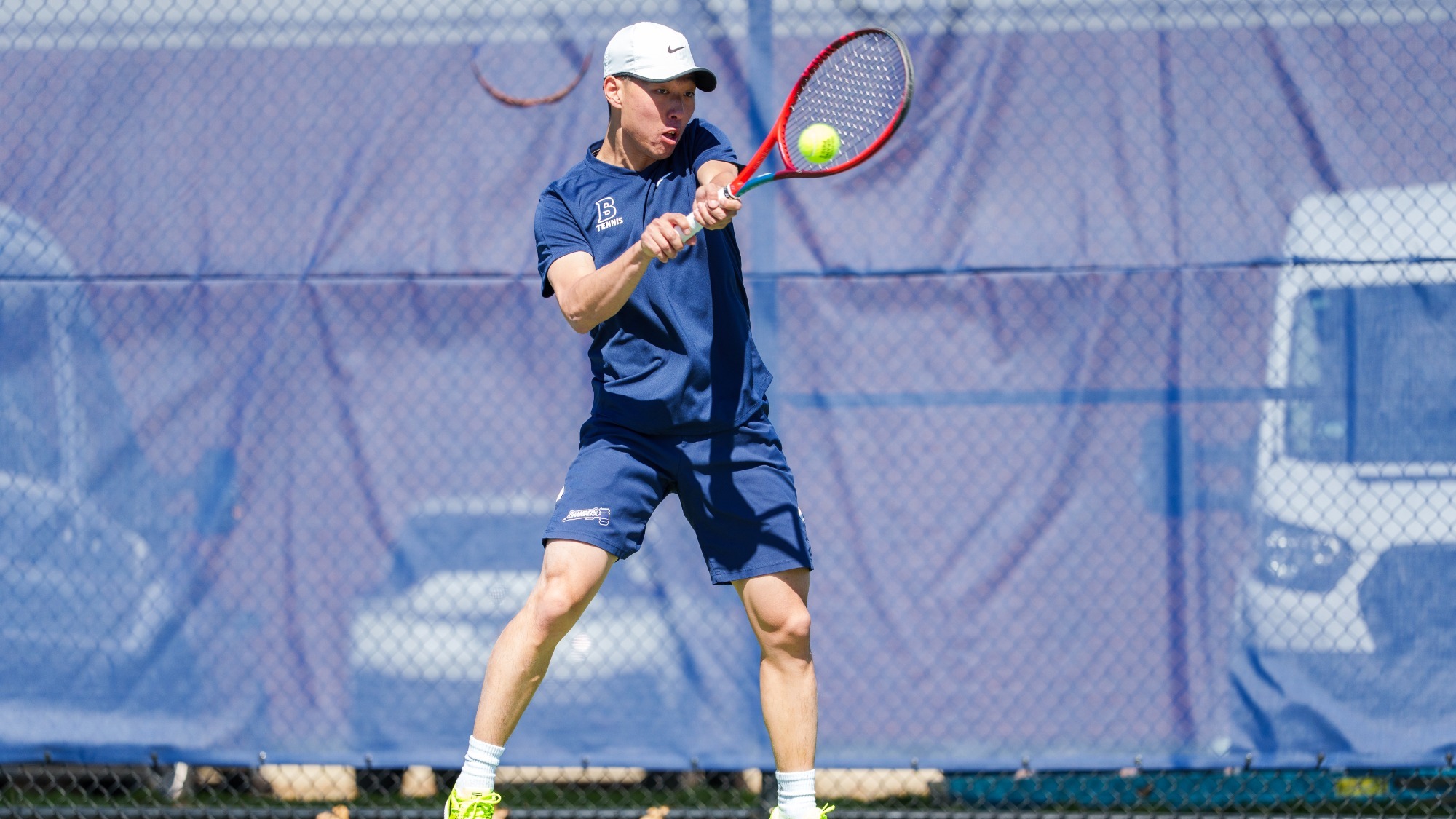 Huasen Dong hits a backhand return during a tennis match
