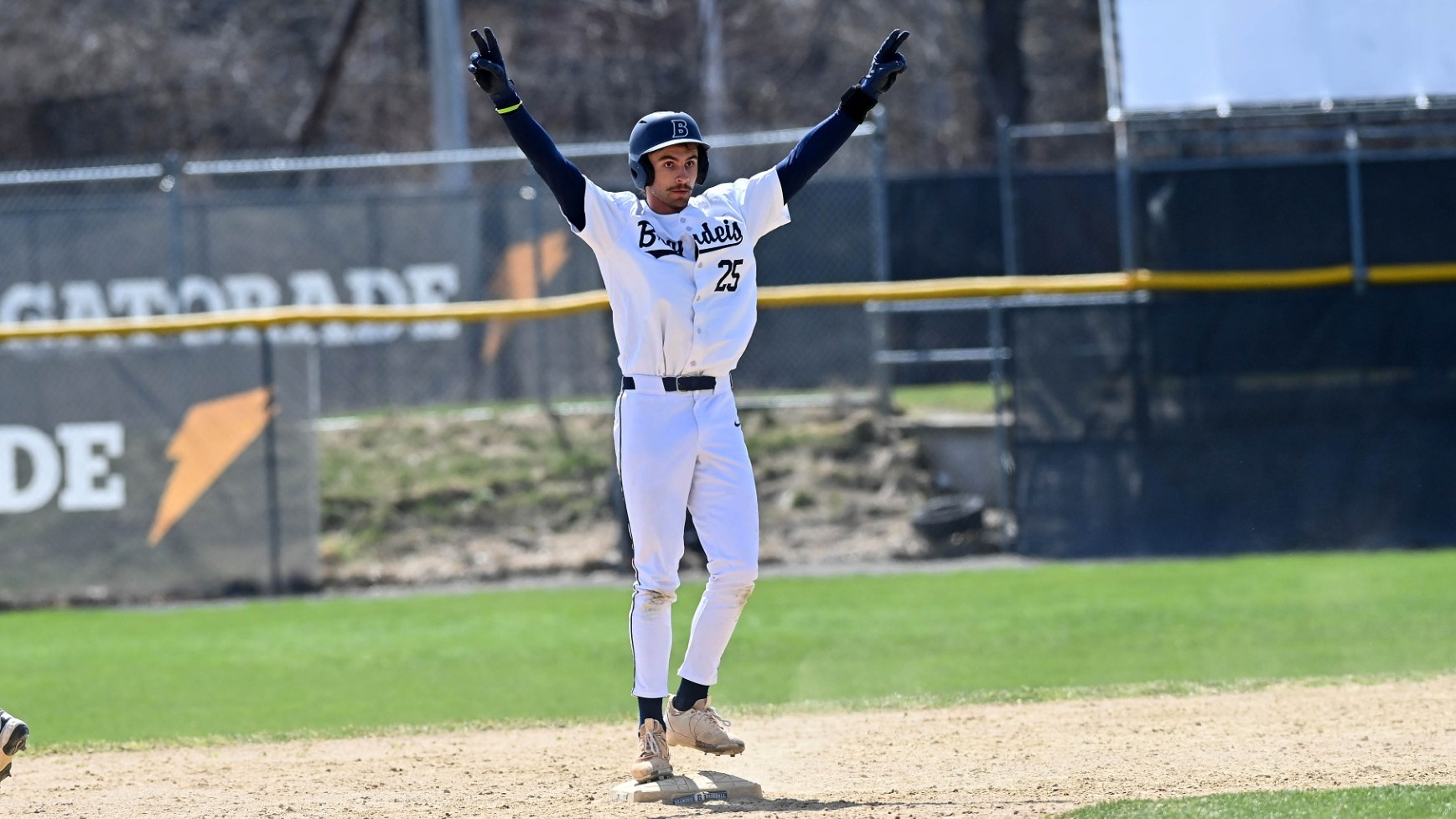 Danny Tambascia standing on second base during a baseball game with his arms raised making V signs with his fingers