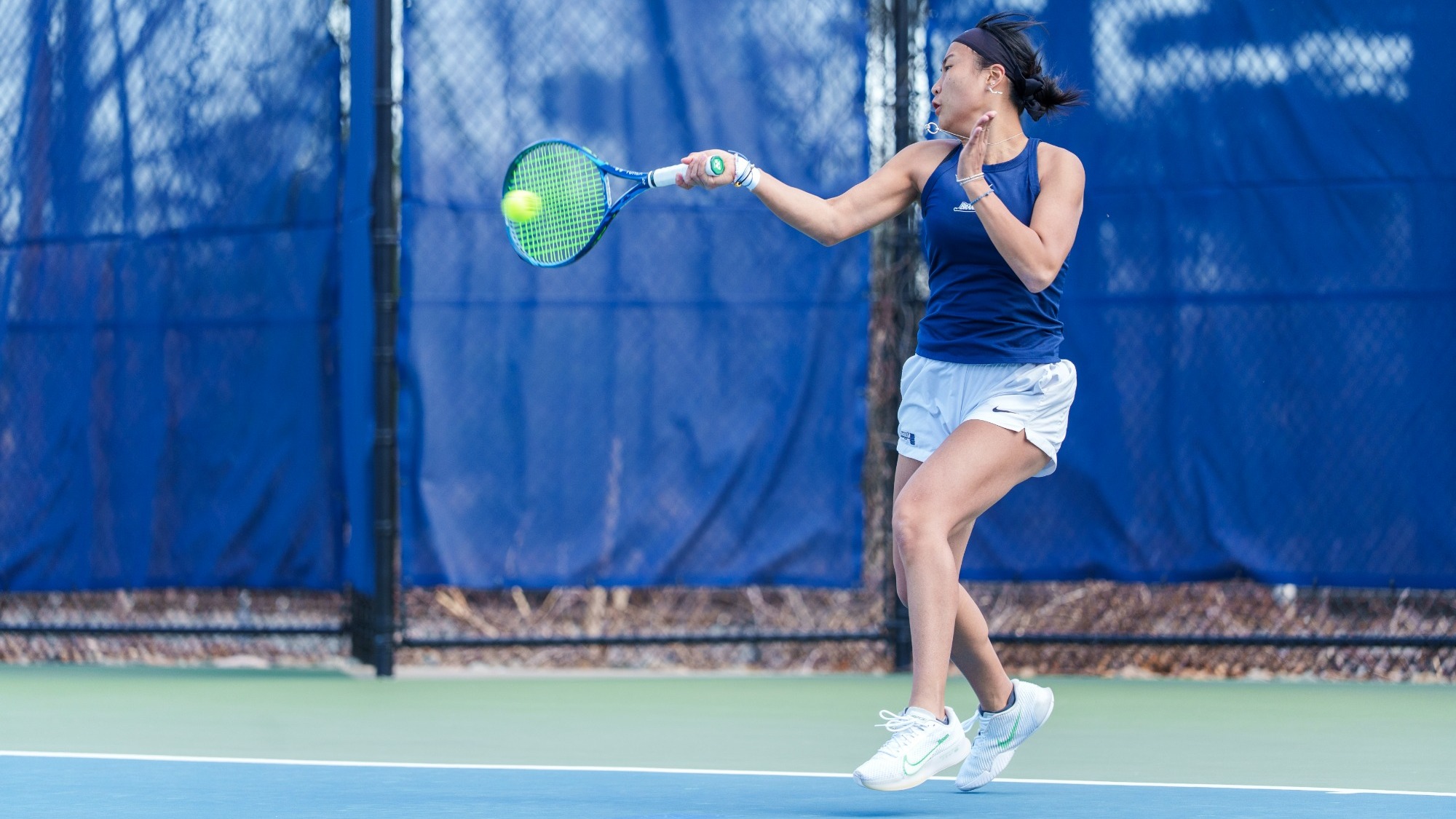 Nancy Zhang hits a forehand during a tennis match
