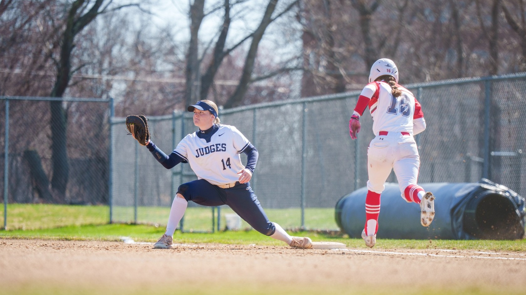 Brooke Boehmer stretches at first base to make an out during a softball game