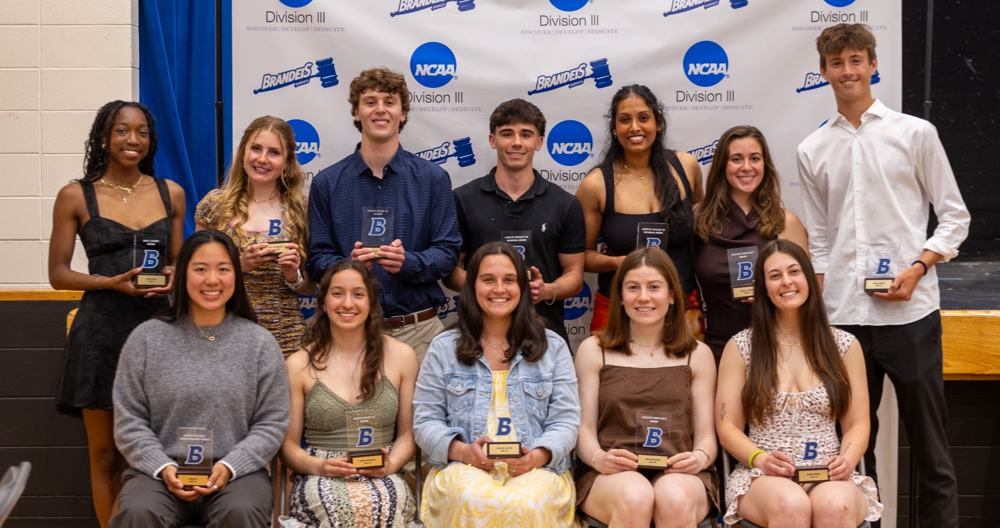 Two rows of student athletes holding awards