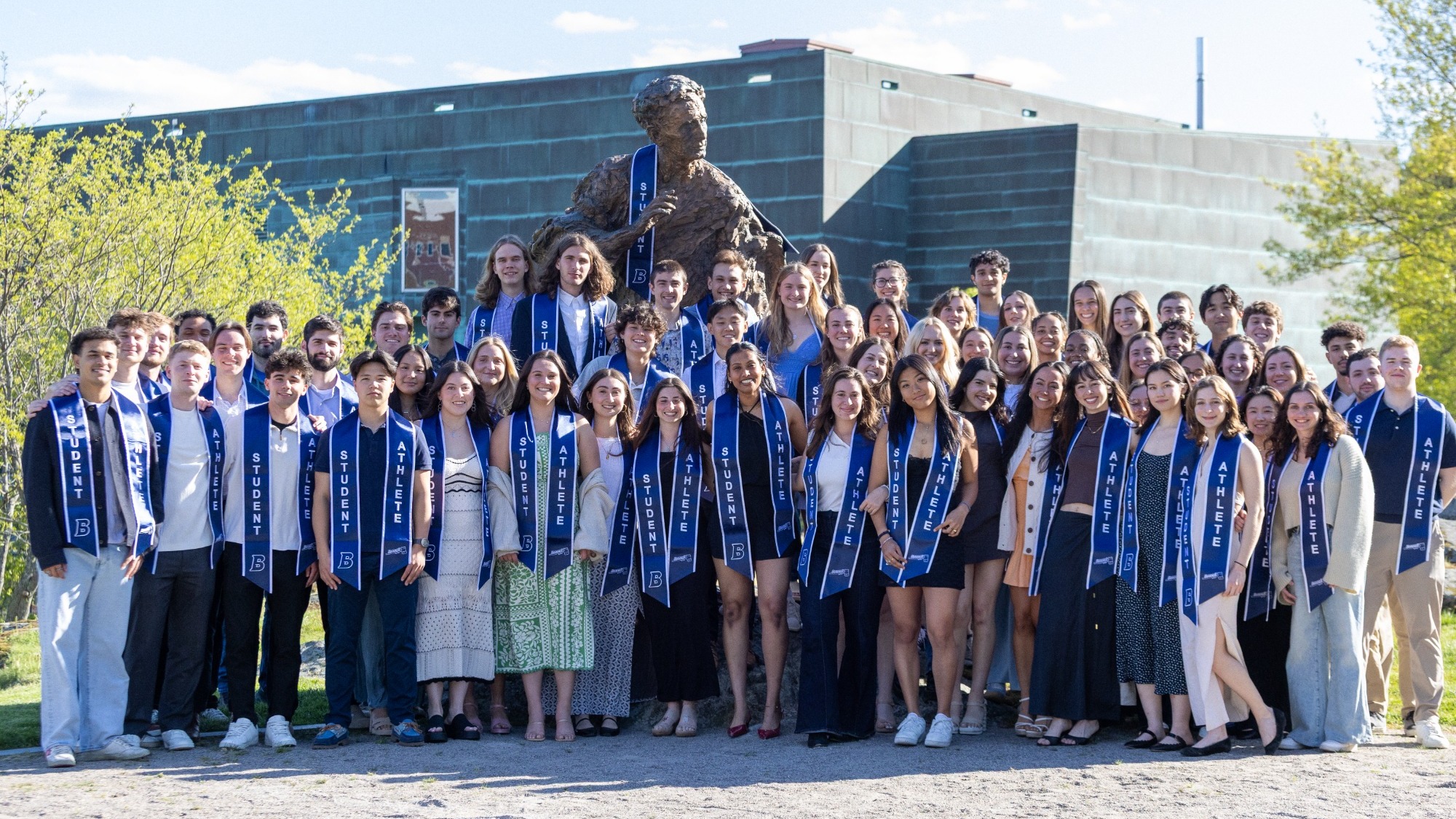 Brandeis Senior Student-Athletes pose with their stoles and the Louis Brandeis statue after Charlie's Reception