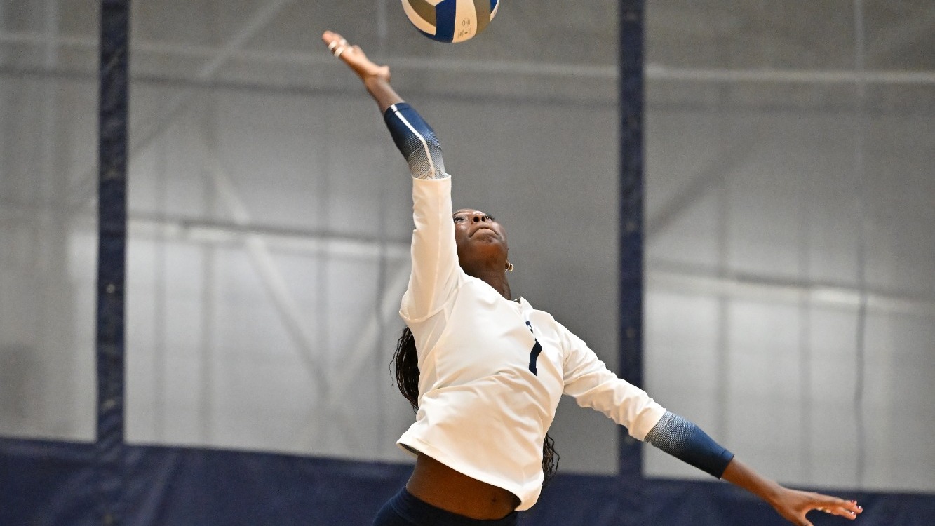 Kennedy Hilson serves a volleyball