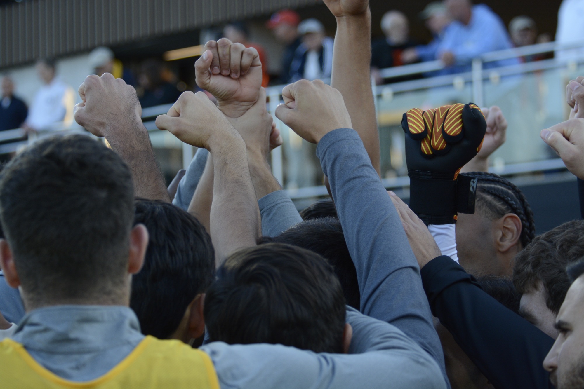 The Men's Soccer team have a moment of unity, breaking out of the huddle before the match with their fists closed