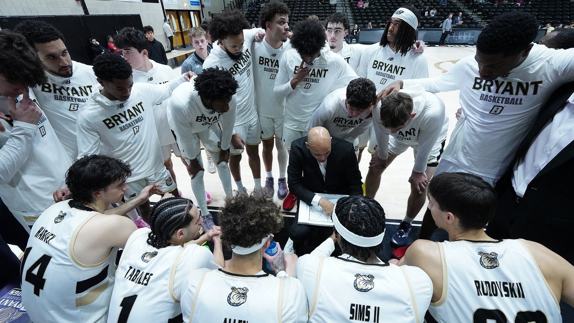 Team Huddles around Jamion Christian who is drawing up plays